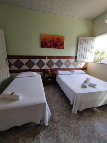 a room with two beds in a room at Pousada Arco Iris Ilhéus in Ilhéus