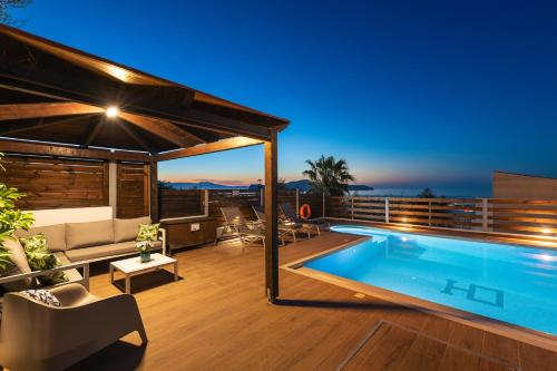 a house with a swimming pool at night at Seaview Garden Villa - Heated Pool & Sauna in Stalos