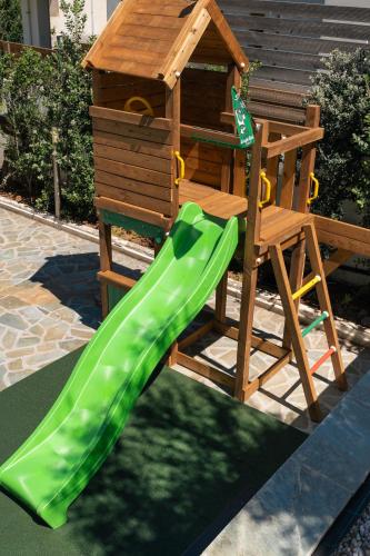 a playground with a slide and a wooden playset at Seaview Garden Villa - Heated Pool & Sauna in Stalos