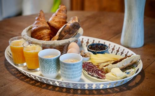 uma bandeja de alimentos e bebidas para o pequeno-almoço numa mesa em Les Jardins de Félicie em Poses