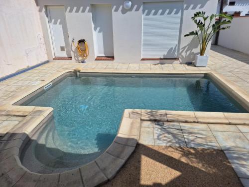 - une petite piscine dans une cour avec une terrasse dans l'établissement La Cannetoise, à Canet