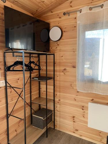 a room with a wooden wall with a shelf and a window at Eco-Lodge de Cëuse in Sigoyer