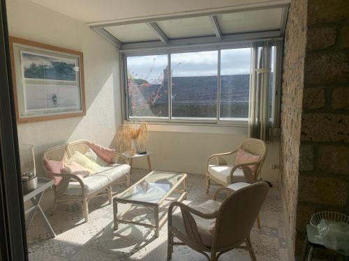 - un salon avec des chaises, une table et une fenêtre dans l'établissement Carnac, à Carnac