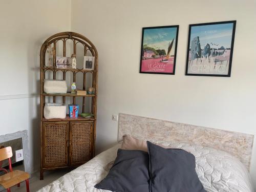Cette chambre comprend un lit et une étagère avec des photos. dans l'établissement Carnac, à Carnac