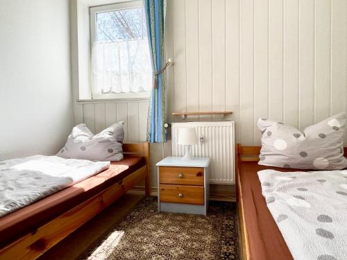 - une petite chambre avec 2 lits et une fenêtre dans l'établissement Ferienwohnung ‘Storchennest’, à Tauche