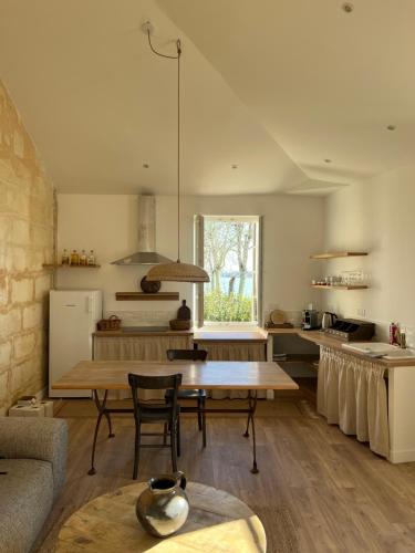 un salon avec une table et une cuisine dans l'établissement La Villa du fleuve, à Quinsac