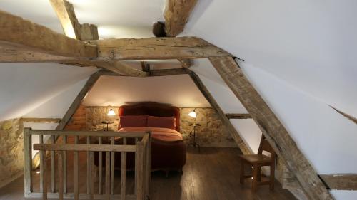 a attic room with a bed and a staircase at Le Moulin du Clapier La Banette in Sorges