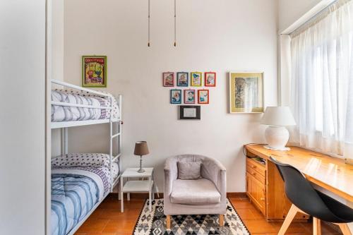 1 dormitorio con litera, silla y escritorio en Welcome Home, en Lido di Ostia