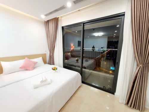 - une chambre avec un lit blanc et une grande fenêtre dans l'établissement Studio Luxury Apt D'Capitale #Jerry's House, à Hanoï