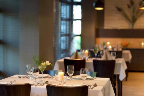 a dining room with white tables and chairs with candles at Najpiękniejszy Bezpośredni Widok na Bałtyk - Twój Apartament in Sarbinowo