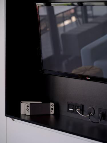 a television with a remote control on top of it at Najpiękniejszy Bezpośredni Widok na Bałtyk - Twój Apartament in Sarbinowo