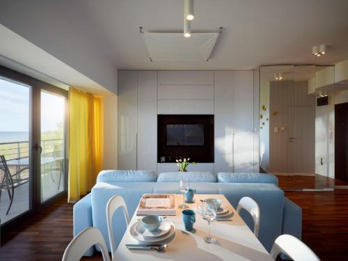 サルビノボにあるNajpiękniejszy Widok na Bałtyk - Twój Apartamentのリビングルーム(青いソファ、テーブル付)