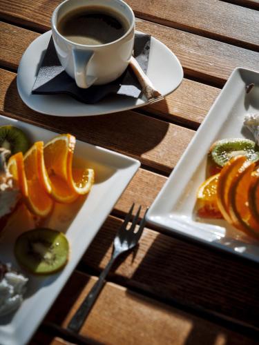 a table with two plates of food and a cup of coffee at Najpiękniejszy Bezpośredni Widok na Bałtyk - Twój Apartament in Sarbinowo