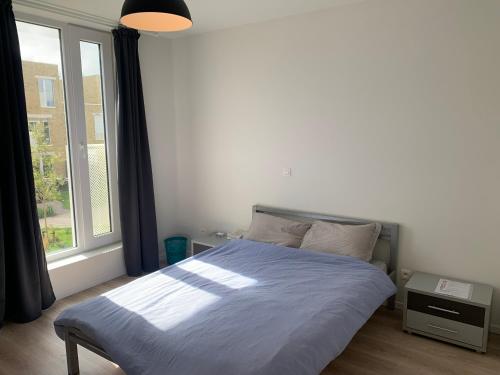 una camera con un letto e una grande finestra di Private Room in Shared House a Ostenda