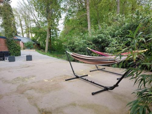 a hammock is sitting in a park at Gîte à la campagne in Ghissignies