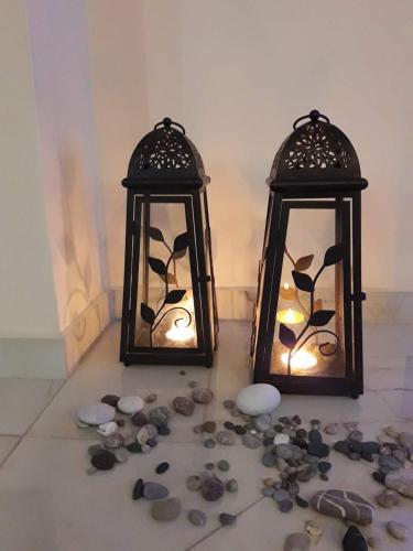 a couple of lanterns sitting on a floor with rocks at Hermes in Agia Marina Aegina