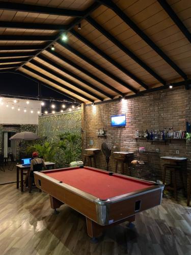 a pool table in a room with a bar at Bali Caps Hostel by Xhosteller in Kuta