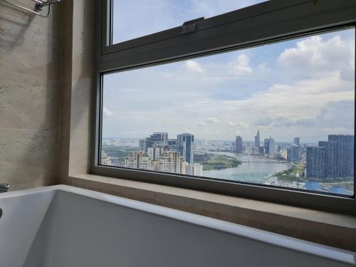 a window in a bathroom with a view of a city at Vinhome Landmark Suites in Ho Chi Minh City