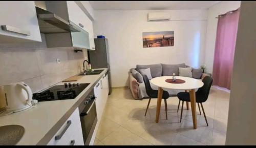 een kleine keuken met een tafel en een bank bij Beach apartment Perisic Podstrana in Podstrana