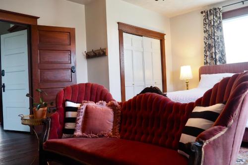 a bedroom with a bed and two red chairs at Firefly Hills in Beattyville