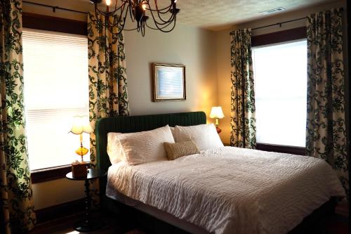 een slaapkamer met een bed en 2 ramen bij Firefly Hills in Beattyville