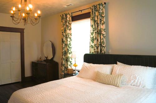 a bedroom with a large white bed with a window at Firefly Hills in Beattyville