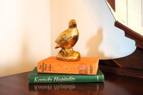 a statue of a bird sitting on top of two books at Firefly Hills in Beattyville