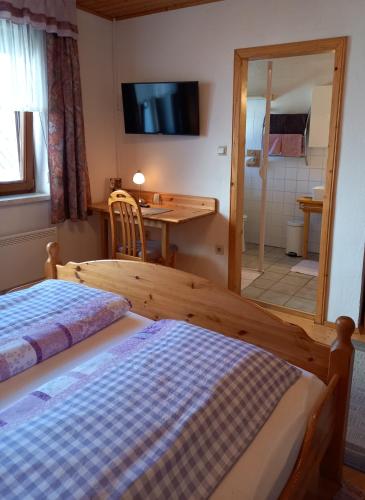 a bedroom with two beds and a desk and a television at Winzerhof Fleischmann in Kleinhöflein