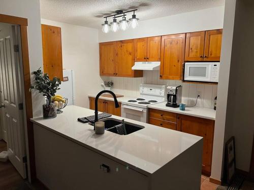 a kitchen with wooden cabinets and a white counter top at TOP FLOOR at very Base of Hill w AC & Best Views on Mountain in Panorama