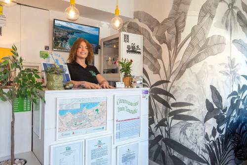 a woman standing behind a counter in a room at B&B Sorrento Central in Sorrento