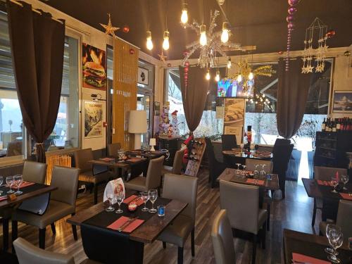 a restaurant with tables and chairs and a chandelier at La Trinite in Saint Firmin