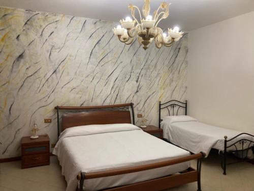 a bedroom with two beds and a stone wall at B&B La Terrazza Dell'Itria in Modica