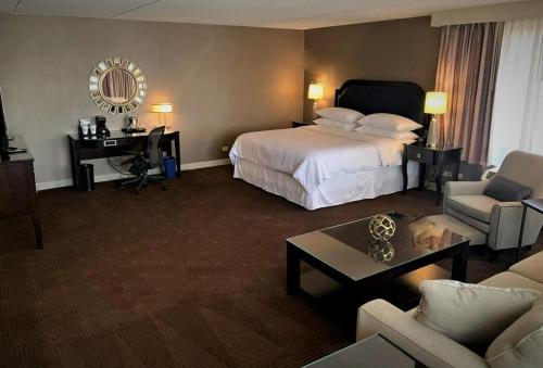 a hotel room with a bed and a desk at Sheraton Lisle Naperville Hotel in Lisle