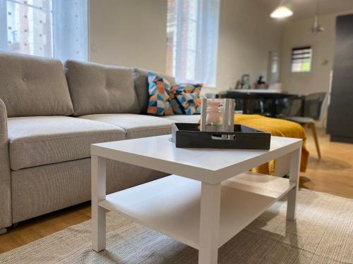 a living room with a couch and a white coffee table at Appartement coeur centre ville in Noyon