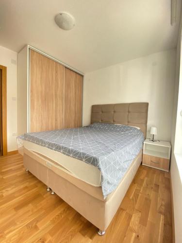 a large bed in a room with a wooden floor at Apartman Sky view - Sokobanja in Soko Banja