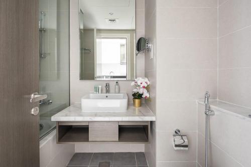 ein weißes Badezimmer mit einem Waschbecken und einem Spiegel in der Unterkunft Frank Porter - Prive A in Dubai