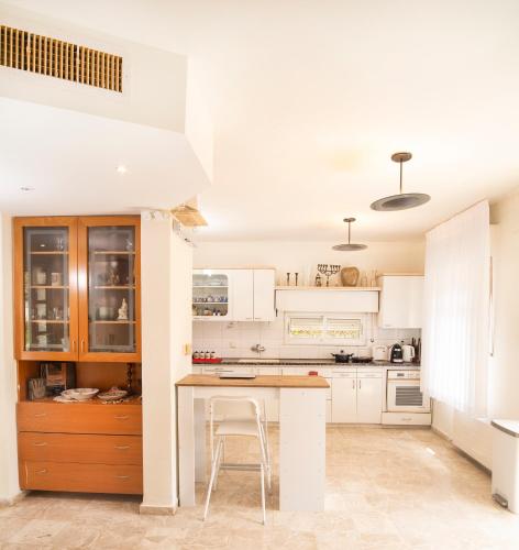 a kitchen with white cabinets and a wooden table at Exclusive Jerusalem Villa in Jerusalem