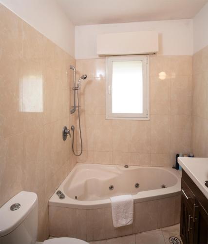 a bathroom with a tub and a toilet and a window at Exclusive Jerusalem Villa in Jerusalem