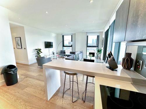 cocina y sala de estar con una gran encimera blanca en Battersea 3 Bedroom penthouse with private terrace, en Londres