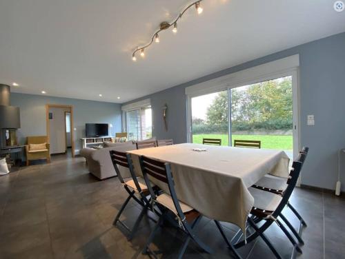 une salle à manger avec une table et des chaises et un salon dans l'établissement Belle maison en bois Perros - La lande, à Perros-Guirec