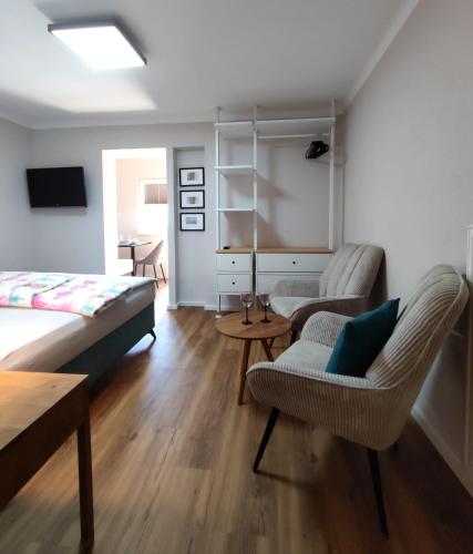 a living room with a bed and two chairs at Haus Nowak Ferienwohnungen in Millstatt