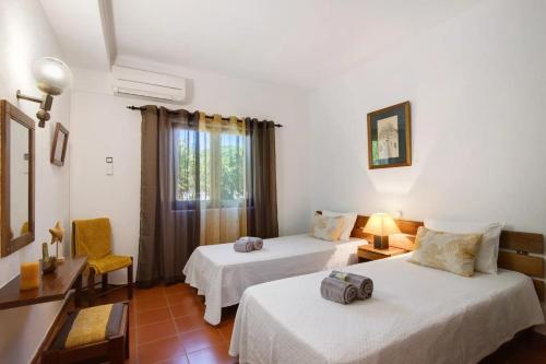 Cette chambre comprend 2 lits et une fenêtre. dans l'établissement Casa Mila by Sunnyway, à Olhos de Água