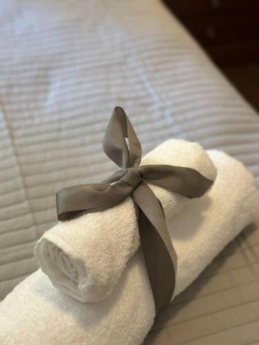 toalla plegable con cinta negra en la cama en Casa moderna en Lujan de Cuyo 4Pax - by Inside en Mayor Drumond