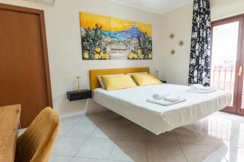 een slaapkamer met een bed met een schilderij aan de muur bij Appartamento Georgiana in Taormina