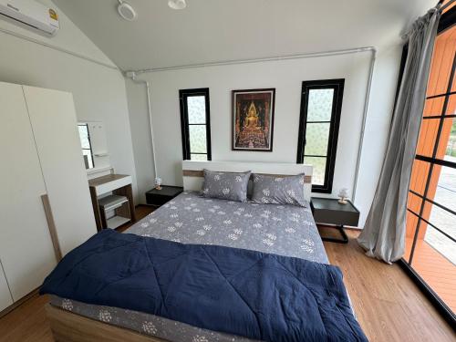 um quarto com uma cama num quarto com janelas em „Mayuree“ - Homestay em Kranuan