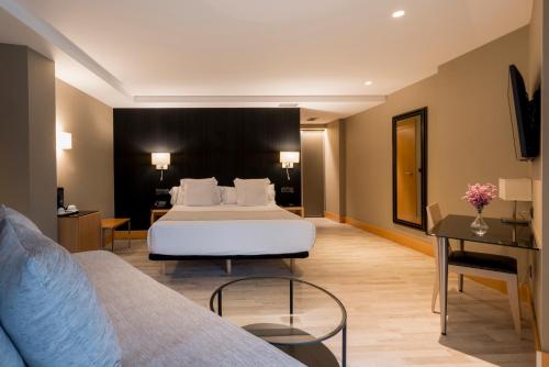 a hotel room with a bed and a desk at Hotel Plaza in A Coruña