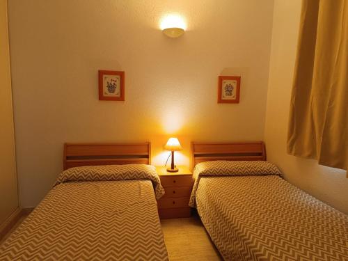 two twin beds in a room with a lamp at Vera Natura, Apartamento Carmen in Vera