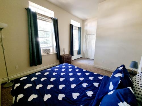 a bedroom with a blue bed with white hearts on it at Lovely Spacious 1br Apt With Patio in Philadelphia