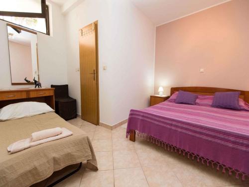 - une chambre avec 2 lits dotés de draps violets et d'un miroir dans l'établissement Apartments in Crikvenica 5669, à Crikvenica