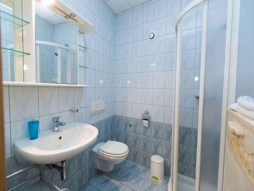 La salle de bains blanche est pourvue d'un lavabo et de toilettes. dans l'établissement Apartments in Crikvenica 5669, à Crikvenica